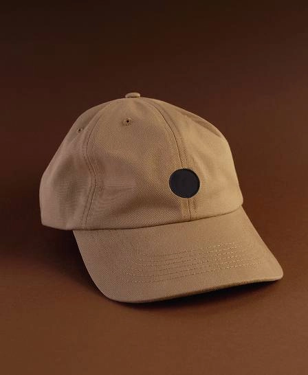 Casquette beige sur fond marron.