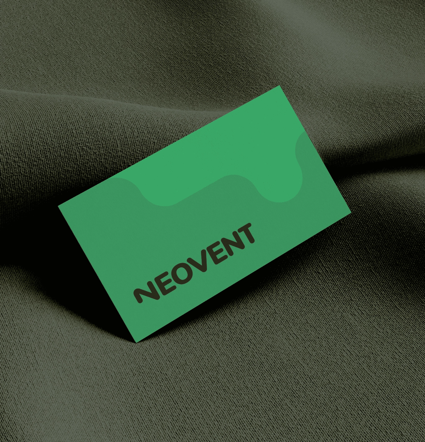 Carte de visite verte sur tissu gris.